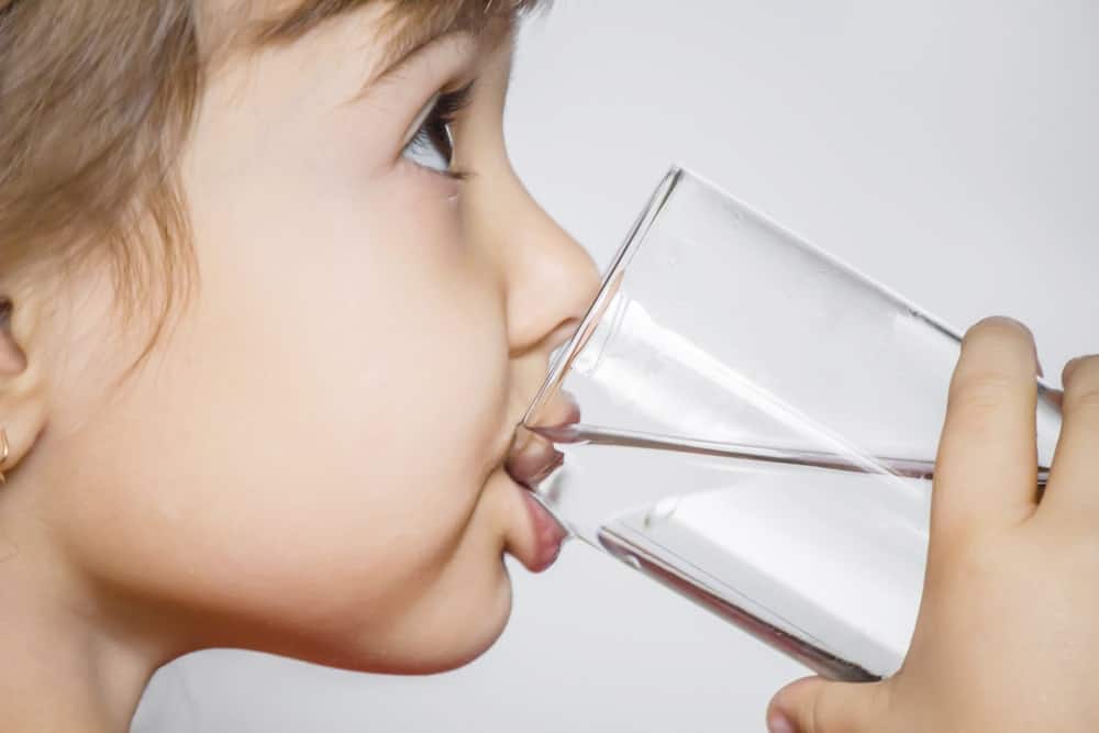 Young girl drinking water from a glass