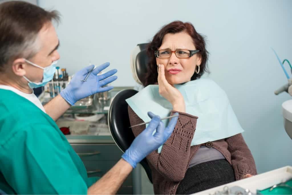 Dentist talking to patient in pain